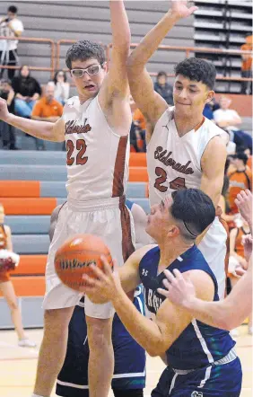  ?? JIM THOMPSON/ALBUQUERQU­E JOURNAL ?? In a Nov. 30 game, Eldorado’s Tyler Rodgers (22) and Kameron Valencia (24) try to block the shot of Rio Rancho’s Derrick Reyes (31).