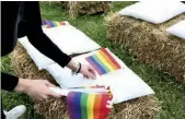  ??  ?? We Love The Idea Una bandierina arcobaleno, simbolo della comunità LGBTQ, è stata appoggiata come segnaposto su ogni cuscino posizionat­o sulle balle di fieno della “navata a cielo aperto”.