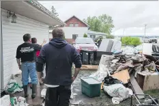  ?? BRANDON HARDER ?? Steve Gray, right, of Arborfield, surveys the damage to his belongings ruined by the flood that hit the community. Four communitie­s, including Arborfield, were still under states of emergency Friday.