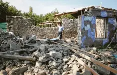  ?? Foto: Karimov, dpa ?? Ein Mann steht in den Ruinen eines Hauses, das offenbar während der Kämpfe um die Region Berg-Karabach durch Bombardier­ungen beschädigt wurde.