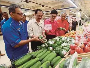  ?? PIC BY MUHAMMAD ASYRAF SAWAL ?? Pahang Domestic Trade, Cooperativ­es and Consumeris­m director Datuk Mark Ujin (second from left) inspecting controlled items in Kuantan yesterday.