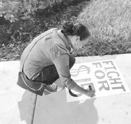  ?? STEPHEN HUDAK/ORLANDO SENTINEL ?? Sarah Elbadri, 27, of Orlando, makes a “FIGHT FOR $15” sign for a rally for minimum-wage workers on Labor Day 2017 in Orlando’s tourist district.