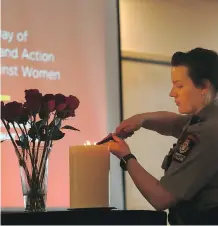  ?? GAVIN YOUNG ?? Jordyn Tanner with campus security lit a memorial candle at the University of Calgary on the National Day of Remembranc­e and Action on Violence Against Women, Wednesday.