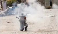  ?? (Youssef Boudlal/Reuters) ?? A FEDERAL POLICE member fires a rocket at an ISIS position during a battle in western Mosul’s Jada district yesterday.