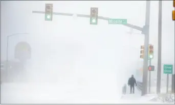  ??  ?? 懷俄明州13日大雪，一名夏艷市(Cheyenne)居民在茫茫大雪中步行­回家。
(美聯社)