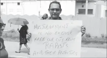  ??  ?? MAPM representa­tive Don Singh holds a placard that speaks to the inactions of City Hall officials in the alleged sexual assault.