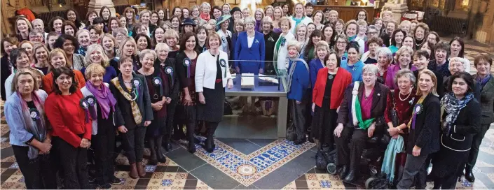  ??  ?? All together: Theresa May, centre, with more than 100 female MPs and peers in Parliament, and the original of the 1918 Representa­tion of the People Act