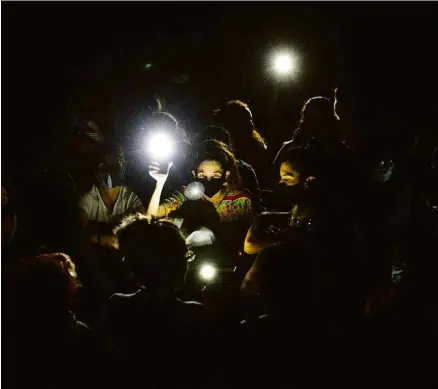  ?? Yamil Lage - 28.nov.20/AFP ?? Ativistas usam luzes de telefones para protestar em frente ao Ministério da Cultura, em Havana