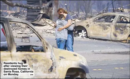  ?? EPA ?? Residents hug after viewing their destroyed homes in Santa Rosa, California on Monday.