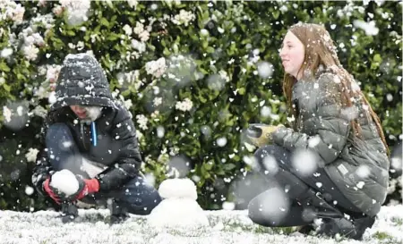  ?? WILL LESTER/THE ORANGE COUNTY REGISTER ?? Brody Mielke, left, and sister Braelynn play in the snow Saturday in Fontana, Calif.