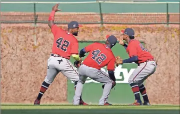  ?? USA Today Sports - David Banks ?? Above: From left, outfielder­s Marcell Ozuna, Guillermo Heredia and Ronald Acuña Jr. celebrate following the Braves’ win over the Cubs on Friday at Wrigley Field. Below: Braves catcher Travis d’arnaud catches a foul ball hit by the Cubs’ Javier Baez during the eighth inning.