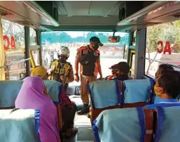  ?? UMAR/JAWA POS ?? RAZIA GABUNGAN: Aparat Polres Pelabuhan Tanjung Perak dan satpol PP mengadakan operasi yustisi penegakan protokol kesehatan. Foto kanan, polisi memeriksa penumpang bus yang tidak menggunaka­n masker.