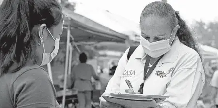  ?? FEDERICA NARANCIO/AP ?? A health promoter from CASA tries to enroll Latinos as volunteers to test a potential COVID-19 vaccine at a farmers market in Takoma Park, Maryland.