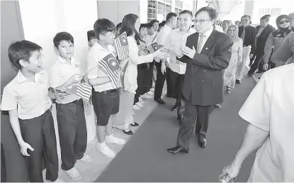  ??  ?? MESRA: Abang Johari disambut meriah oleh murid-murid SJKC Stampin semasa majlis penyerahan kunci bangunan baharu sekolah tersebut pada 19 November tahun lalu.