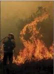  ??  ?? In this Monday photo, firefighte­rs battle a brushfire burning off State Route 91, between Anaheim and Corona. WATCHARA PHOMICINDA/THE ORANGE COUNTY REGISTER VIA AP