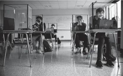  ?? Jessica Hill / Associated Press ?? Students listen to a presentati­on in health class at Windsor Locks High School in Windsor Locks, Conn. The Centers for Disease Control and Prevention relaxed its social distancing guidelines for schools Friday, saying students can sit 3 feet apart in classrooms.