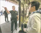  ??  ?? WORKERS WERE dispatched to provide informatio­n to passengers, authoritie­s said. Above, a police officer directs a traveler at Terminal 7.