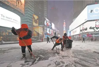  ??  ?? ROBERT DEUTSCH/ USA TODAY Workers clear snow in Times Square in New York. Snow was on the ground from Florida to Maine.