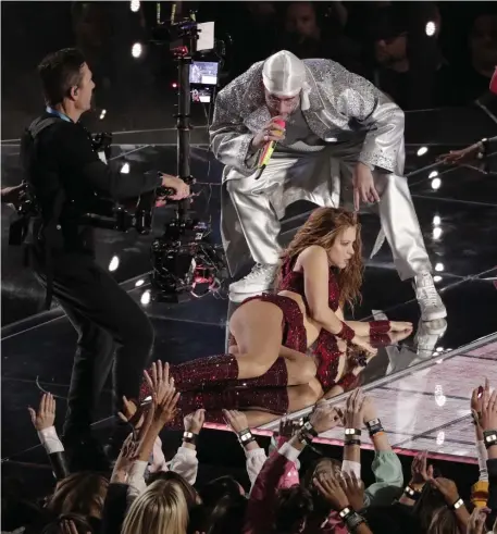  ?? AP FILE PHOTOS ?? SUPER SUCCESS: Bad Bunny performs with Shakira during halftime of this year’s NFL Super Bowl in Miami. At left, Bad Bunny poses with the award for best urban music album at the Latin Grammy Awards in Las Vegas in November 2019.