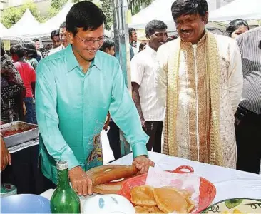  ??  ?? Dough-ing it right: Raja Nong Chik making ‘poori’ during the fun fair organised by the Temple of Fine Arts in Brickfield­s yesterday.