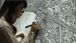  ?? NG HAN GUAN/ASSOCIATED PRESS ?? Chinese artist Yang Qian uses dots to recreate an aerial view of Wuhan under lockdown at her studio in Wuhan in central China’s Hubei province.