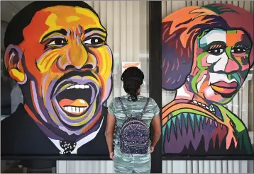  ?? CHRIS RILEY — TIMES-HERALD ?? Eloni Williams, 10, who helped paint all of the faces on the Black Dreams mural, reads informatio­n about Dr. Martin Luther King Jr. during the opening of the exhibition at the Boys & Girls Empowermen­t Group on Saturday in Vallejo.