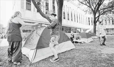  ?? MATHEW MCCARTHY WATERLOO REGION RECORD ?? Pamela Aultman, left, and Sam Stoner set up a tent on the front lawn of the Region of Waterloo building at Queen and Weber streets.