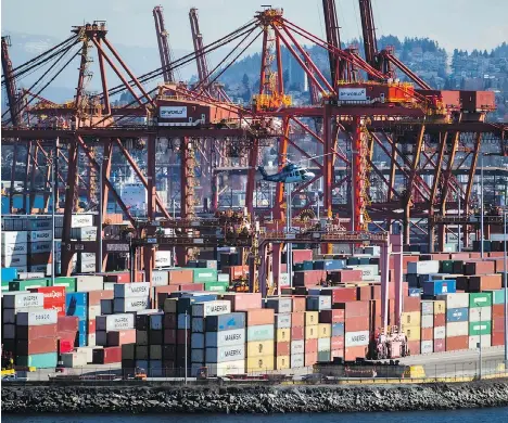  ?? DARRYL DYCK/THE CANADIAN PRESS ?? A Helijet helicopter preparing to land at the harbour passes by cranes used to load and unload container ships at the DP World marine terminal at Port Metro Vancouver. Port Authority boss Robin Silvester says capacity needs to be added quickly to meet demand.