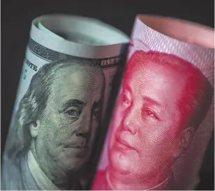  ?? BLOOMBERG PHOTO ?? A U.S. $100 bill and a Chinese one-hundred yuan banknote.