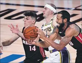  ?? Wally Skalij Los Angeles Times ?? THE LAKERS’ Alex Caruso battles for a loose ball with the Heat’s Tyler Herro, left, and Andre Iguodala in the third quarter in Game 3 of the NBA Finals.