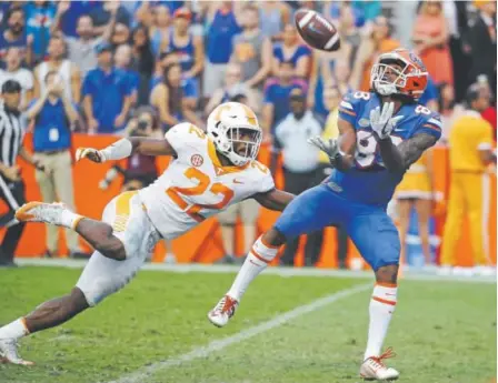  ?? John Raoux, The Associated Press ?? Florida wide receiver Tyrie Cleveland hauls in the game-winning, 63-yard touchdown pass ahead of Tennessee defensive back Micah Abernathy as time expires in the fourth quarter of Saturday’s game.