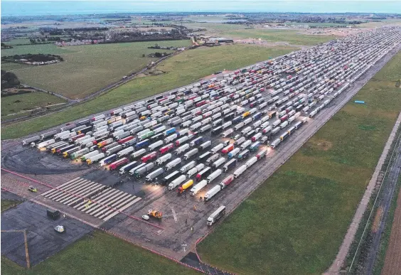  ??  ?? Trucks parked on the tarmac at Manston Airport in southeast England after France closed its borders to accompanie­d freight arriving from the UK due to the rapid spread of a new coronaviru­s strain. Picture: AFP