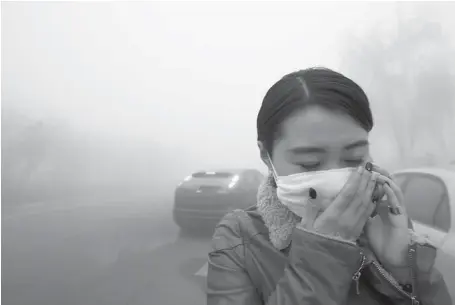  ?? AFP/GETTY IMAGES ?? A woman walks in the smog in Harbin, northeaste­rn China, Monday, as small-particle pollution hit levels 40 times higher than internatio­nal standards.