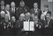  ?? E. JASON WAMBSGANS/CHICAGO TRIBUNE ?? President Donald J. Trump signs an executive order establishi­ng a new executive “Commission on Law Enforcemen­t” and the “Administra­tion of Justice” at the Internatio­nal Associatio­n of Chiefs of Police Annual Conference at McCormick Place in Chicago on Monday.