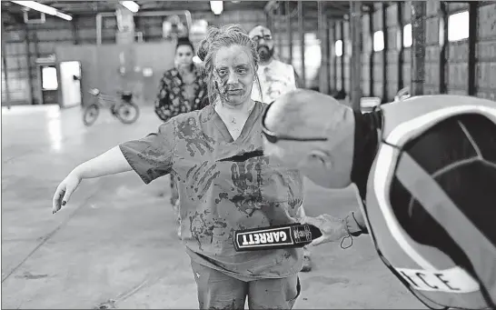  ?? [BROOKE LAVALLEY/DISPATCH PHOTOS] ?? Amanda Swain is checked for weapons before she joins other volunteers dressed as zombies to play the part of an unruly crowd at the 27th Internatio­nal Police Mountain Bike Associatio­n training.