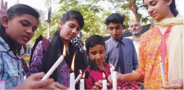  ?? Agence France-presse ?? ↑ People light candles in remembranc­e of the victims of the Christchur­ch mosques attack in Karachi on Monday.