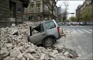  ?? DARKO BANDIC — THE ASSOCIATED PRESS ?? A car is crushed by falling debris after an earthquake March 22 in Zagreb, Croatia.