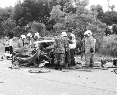  ??  ?? Lundu firemen work to extricate the pinned passenger.