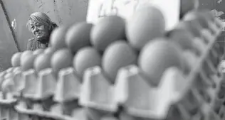  ?? Laszlo Balogh / Associated Press ?? Judit Sos sells eggs last month at a food market in Budapest, Hungary. Higher food prices are pressuring consumer budgets that have been strained by COVID-19 and high energy costs.