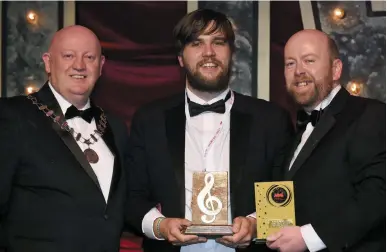  ??  ?? RIGHT: Chris Currid of Avonmore Musical Society, winner of the Best Male Singer Award, Gilbert Section, for his role as Judas in Jesus Christ Superstar receiving the trophy from AIMS president Séamus Power and vice-president Rob Donnelly