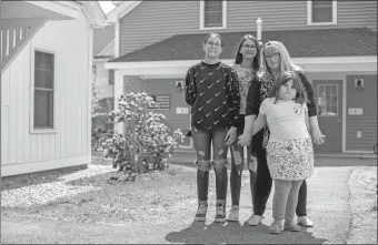  ?? JOHN TULLY/THE WASHINGTON POST ?? Carrie Duran stands with her three children, twins Isabella and Marisole, 13, and Katie, 9, outside their home in Wolfeboro, N.H.