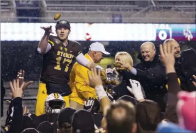  ?? SARWIN OSWALD — THE ASSOCIATED PRESS ?? Wyoming quarterbac­k Josh Allen passes potatoes from the Famous Idaho Potato Bowl trophy to his teammates following the team’s 37-14 victory over Central Michigan on Friday.