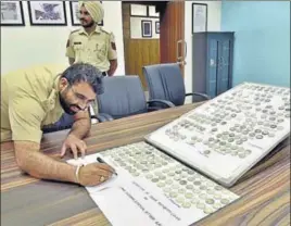  ??  ?? Officials showing the seized coins at Customs House in Amritsar on Tuesday. GURPREET SINGH/HT