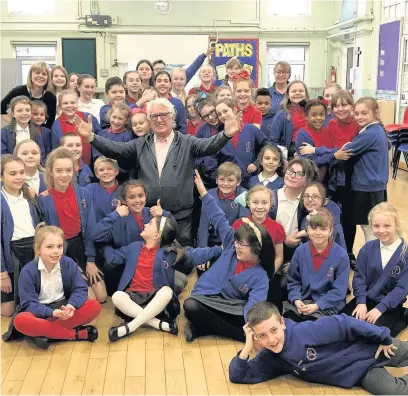  ??  ?? Peter Karrie with Aberdare Town Church Primary School choir ahead of their concert in aid of Cynon Valley PALS