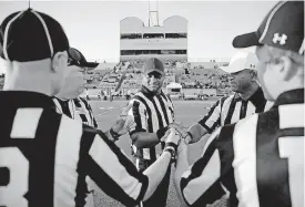  ?? [PHOTO BY BRYAN TERRY, THE OKLAHOMAN] ?? Officials Glen Williams, left, Elgie Hill and Harold Hill gather with official Jason DeBerry, left, not facing camera, and Sam Coldiron.