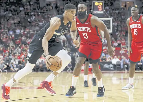  ??  ?? The Bucks’ Giannis Antetokoun­mpo, left, is defended by the Rockets’ James Harden at Toyota Center in Houston.