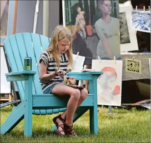  ??  ?? At the 2016 Old Lyme Midsummer Festival, Page Wallace, 8, of Avon snacks while her mother looks at art at the Lyme Academy College of Fine Arts.