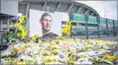  ??  ?? Yellow flowers are displayed in front of the portrait of Argentinia­n forward Emiliano Sala at the Beaujoire stadium in Nantes on Friday