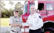  ?? SALLY CARROLL/MCDONALD COUNTY PRESS ?? Missouri Department of Conservati­on Agent Terry Cook presents Goodman Fire Chief Keith Estes with a $3,000 check at Fire Station No. 1 Tuesday night. Estes used the grant to purchase a skid unit, which will be utilized for fighting brush fires.