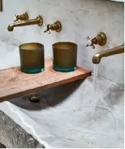  ??  ?? An artisan-designed double stone sink has a striking rustic impact in the bathroom.